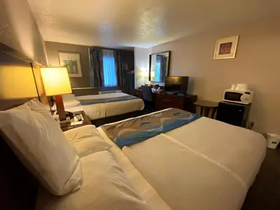 a hotel room with two beds and a television at Travelodge Inn & Suites by Wyndham Albany in Albany