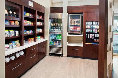 a pharmacy aisle with a refrigerator and drinks at SpringHill Suites by Marriott Carle Place Garden City in Carle Place