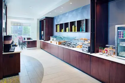 a restaurant with a counter with a buffet at SpringHill Suites by Marriott Carle Place Garden City in Carle Place