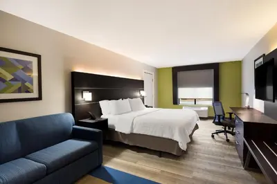 a hotel room with a bed and a couch at Holiday Inn Express Hotel & Suites Newton Sparta by IHG in Newton