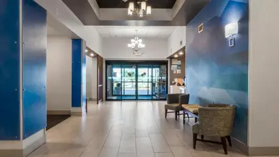 a hallway with blue walls and chairs in a office at Holiday Inn Express Hotel & Suites Newton Sparta by IHG in Newton