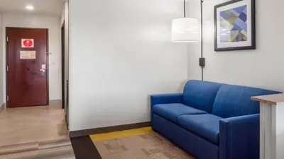 a blue couch in a room with a door at Holiday Inn Express Hotel & Suites Newton Sparta by IHG in Newton