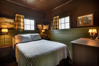 a bedroom with a bed and a sink and windows at The Stables in Kingston