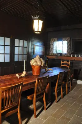 a wooden table with chairs and a pot of flowers on it at The Stables in Kingston
