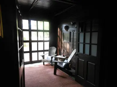 a room with a door and a chair and a table at The Stables in Kingston