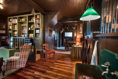 a living room with wooden floors and a green lamp at The Stables in Kingston
