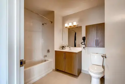 a bathroom with a toilet and a sink and a tub at Global Luxury Suites at Newport in Jersey City