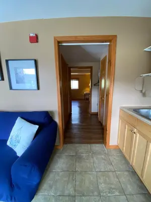 a living room with a blue couch and a kitchen at The Sunview Motel in Tannersville