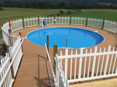 a white fence around a swimming pool in a yard at Apple Inn and Suites Cooperstown Area in Milford