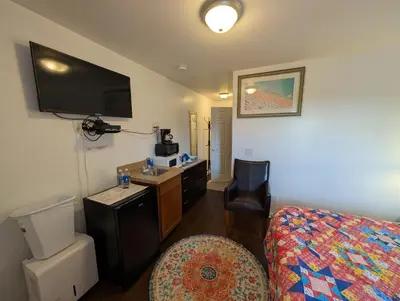 a hotel room with a bedroom with a bed and a sink at Apple Inn and Suites Cooperstown Area in Milford