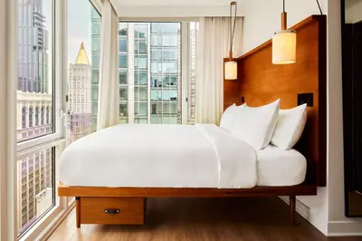 a bedroom with a large bed and a large window at Arlo NoMad in New York