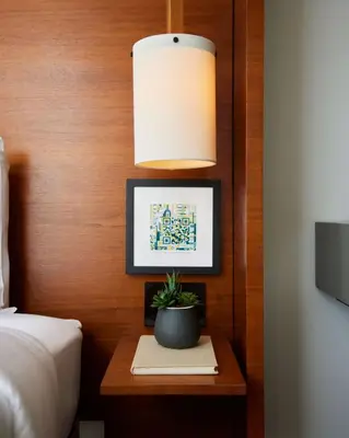 a bedroom with a bed and a potted plant on a table at Arlo NoMad in New York