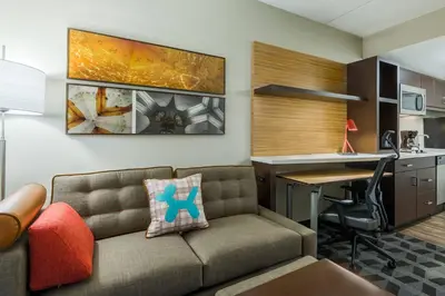 a living room with a couch and a desk at TownePlace Suites by Marriott Latham Albany Airport in Latham