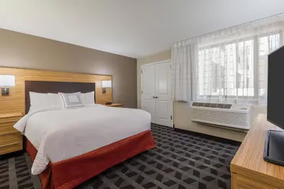 a hotel room with a large bed and a window at TownePlace Suites by Marriott Latham Albany Airport in Latham