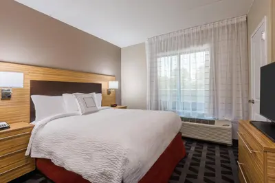 a hotel room with a large bed and a window at TownePlace Suites by Marriott Latham Albany Airport in Latham