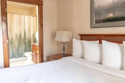 a bedroom with a white bed and a window at Winwood Condominiums by Windham Mountain Club in Windham