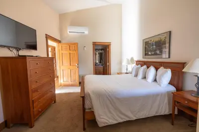 a bedroom with a bed and a flat screen tv at Winwood Condominiums by Windham Mountain Club in Windham