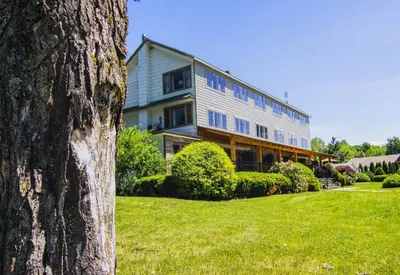 a large house on a green lawn with a tree at Winwood Condominiums by Windham Mountain Club in Windham