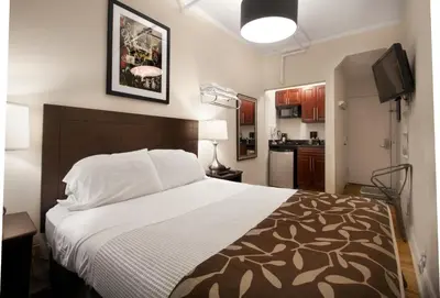 a bedroom with a large bed and a kitchen at Hotel 309 in New York