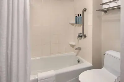 a bathroom with a white tub and a toilet at Fairfield Inn by Marriott New York LaGuardia Airport/Flushing in Queens