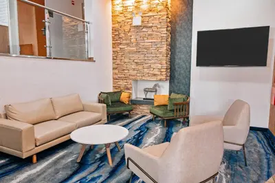 a waiting room with couches and chairs and a fireplace at Fairfield Inn by Marriott New York LaGuardia Airport/Astoria in Queens