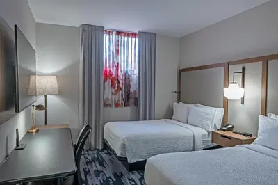 a hotel room with two beds and a desk at Fairfield Inn by Marriott New York LaGuardia Airport/Astoria in Queens