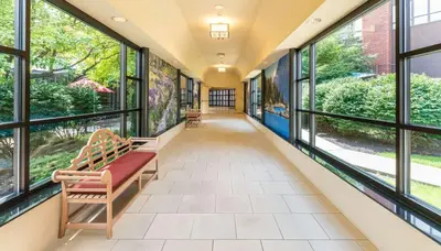 a hallway with windows and a bench in a building at The Saratoga Hilton in Saratoga Springs