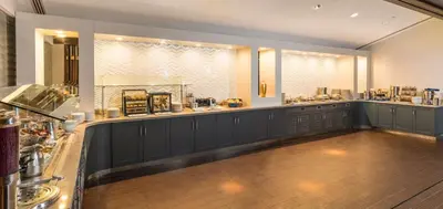 a large room with a counter and aasteryasteryasteryasteryasteryasteryasteryastery at The Saratoga Hilton in Saratoga Springs