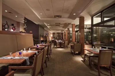a dining room with wooden tables and chairs at The Saratoga Hilton in Saratoga Springs