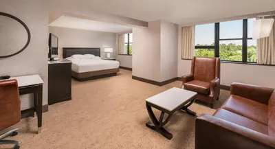 a hotel room with a bed and a desk and chair at The Saratoga Hilton in Saratoga Springs