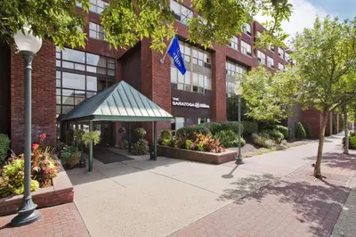 a building with a flag in front of it at The Saratoga Hilton in Saratoga Springs