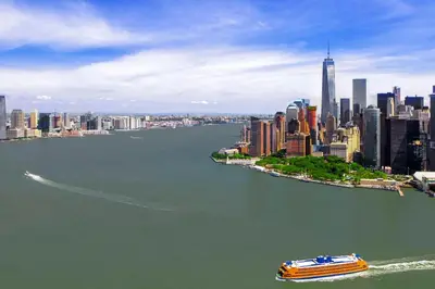 a boat in the water in front of a city at Hyatt Regency Jersey City on the Hudson in Jersey City