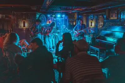 a group of people sitting in a room with a band on a stage at The Red Lion Inn in Stockbridge