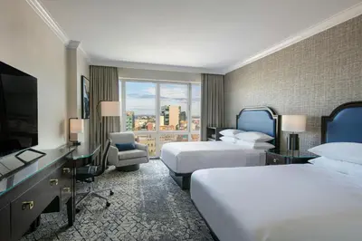 a hotel room with two beds and a flat screen tv at Sheraton LaGuardia East Hotel in Queens