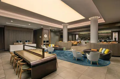 a lobby of a hotel with couches and chairs at Sheraton LaGuardia East Hotel in Queens
