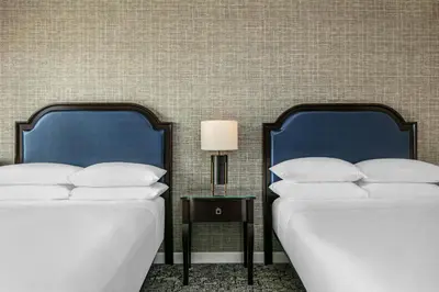 two beds sitting next to each other in a room at Sheraton LaGuardia East Hotel in Queens