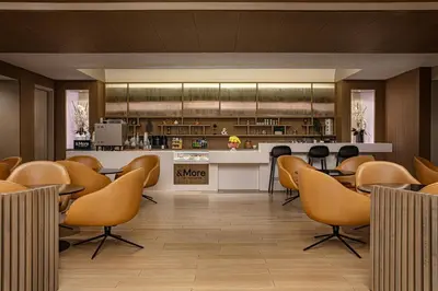 a restaurant with chairs and a counter and a kitchen at Sheraton LaGuardia East Hotel in Queens
