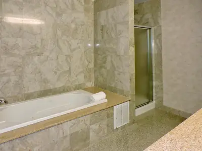 a bathroom with a bath tub and a shower at Marco LaGuardia Hotel & Suites in Queens