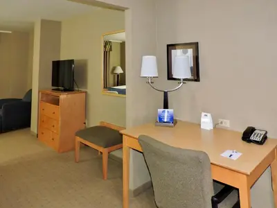 a hotel room with a desk and a television at Marco LaGuardia Hotel & Suites in Queens