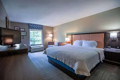 a hotel room with a bed and a flat screen tv at Hampton Inn Hadley-Amherst Area in Hadley