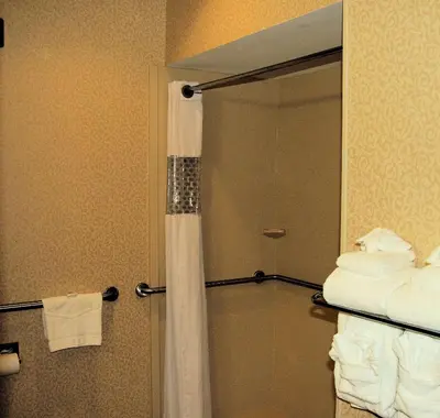 a bathroom with a shower with a curtain and towels at Hampton Inn Hadley-Amherst Area in Hadley