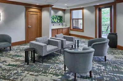 a waiting room with chairs and a table at Hampton Inn & Suites Saratoga Springs Downtown in Saratoga Springs