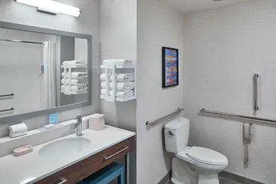 a bathroom with a sink and a toilet and a mirror at Hampton Inn & Suites Saratoga Springs Downtown in Saratoga Springs