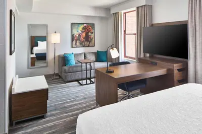 a hotel room with a bed and a desk with a television at Hampton Inn & Suites Saratoga Springs Downtown in Saratoga Springs