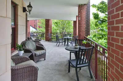 a patio with chairs and tables on a balcony at Hampton Inn & Suites Saratoga Springs Downtown in Saratoga Springs