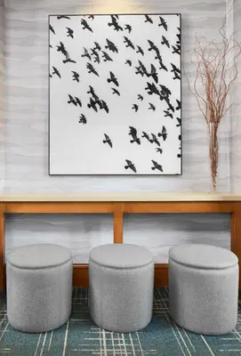two stools in a lobby with a picture of birds at Hampton Inn & Suites Saratoga Springs Downtown in Saratoga Springs