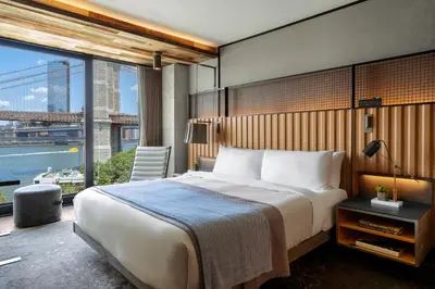 a bedroom with a large bed and a large window at 1 Hotel Brooklyn Bridge in Brooklyn