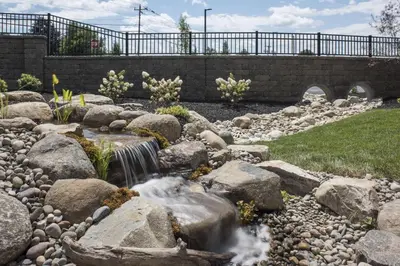 a waterfall in a rock garden with a bridge at Courtyard by Marriott Albany Clifton Park in Clifton Park