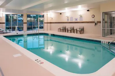 a pool with blue water in a hotel room at Courtyard by Marriott Albany Clifton Park in Clifton Park