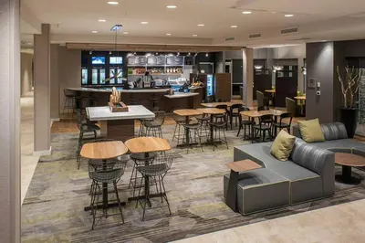a lobby with a couch and tables and a bar at Courtyard by Marriott Albany Clifton Park in Clifton Park